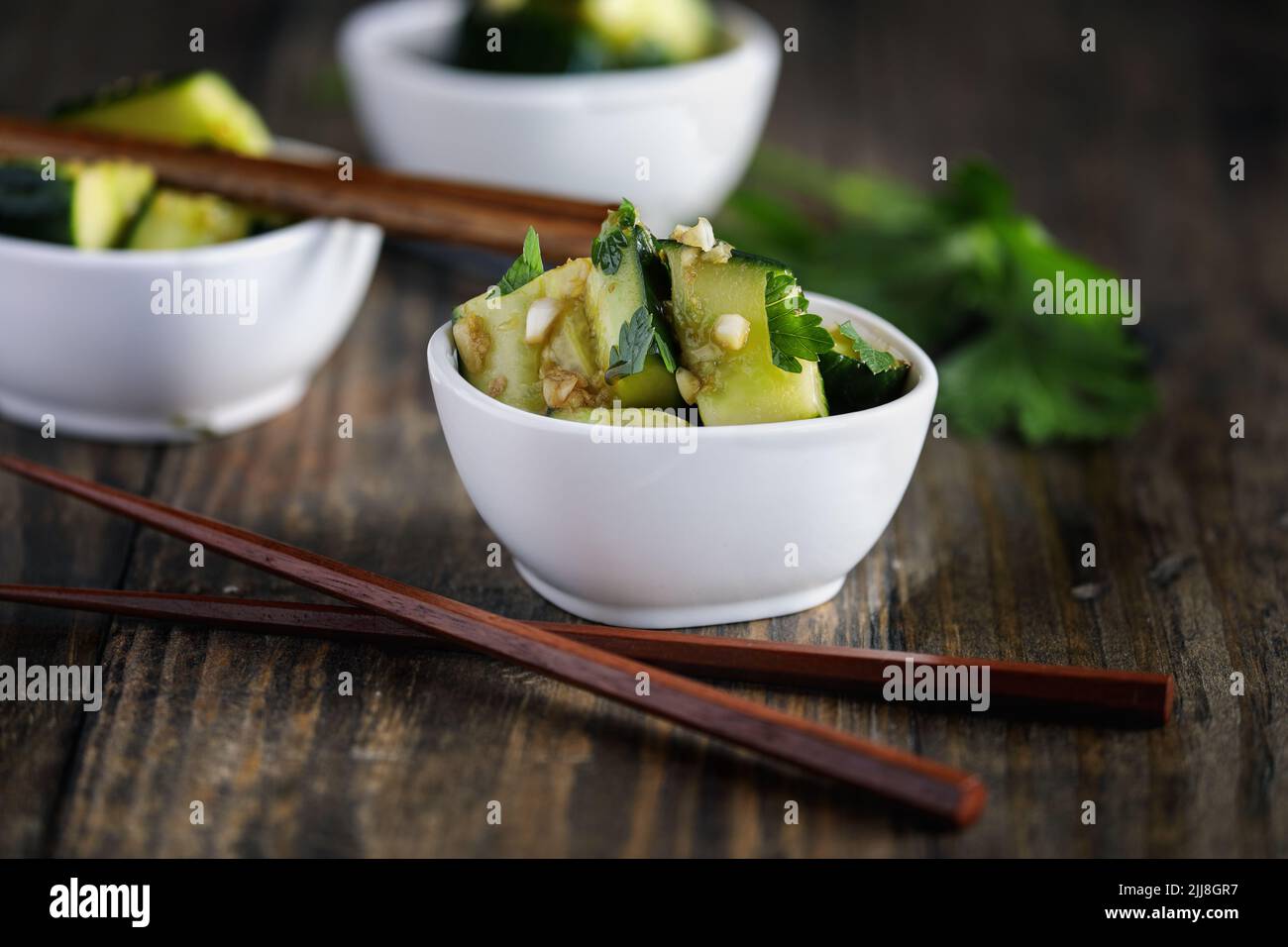 Pai Huang Gua frío, ensalada de pepino triturado chino. Elaborado con ajo, jengibre, aceite de sésamo, salsa de soja y adornado con hojas frescas de cilantro. Extre Foto de stock