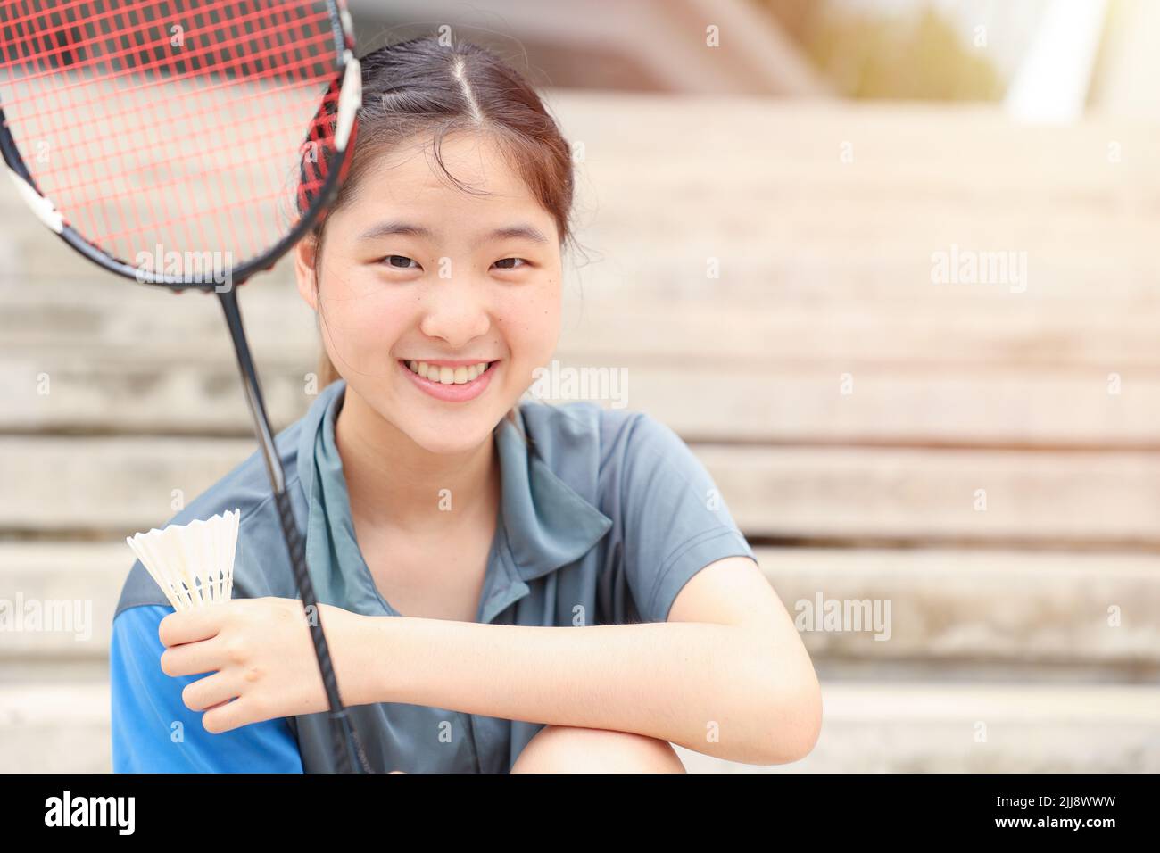 Jugadora deportiva adolescente asiática con equipo de bádminton para un retrato saludable al aire libre sonrisa feliz Foto de stock