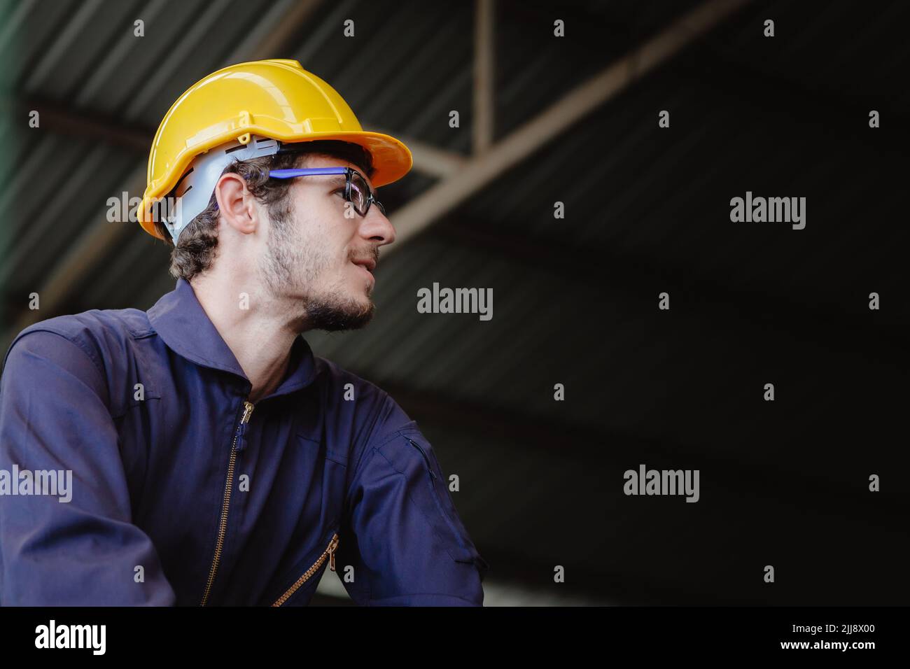 Retrato de joven americano alegre trabajador en ropa de seguridad ingeniero casco casco con espacio de copia. Foto de stock