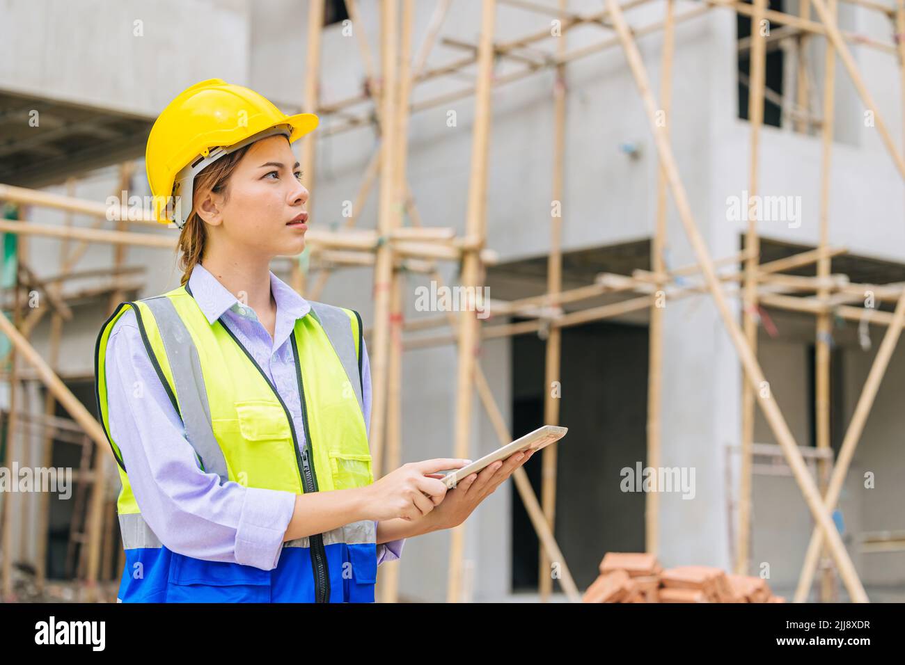 Ingeniero Construction Builder Mujer trabajadora segura de trabajar inteligente en la construcción de mirar el proyecto de construcción de casa. Foto de stock