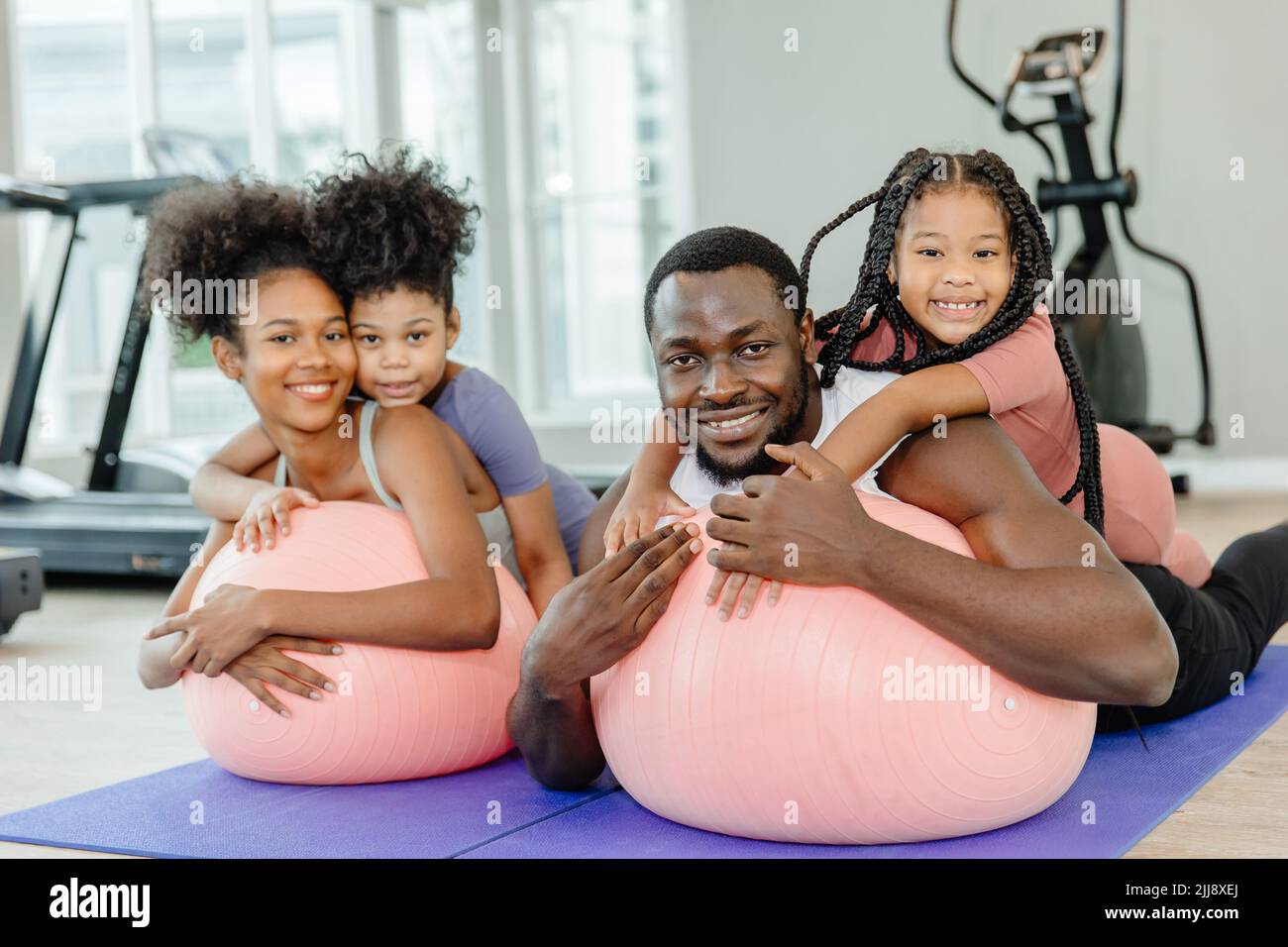 niños sanos de la familia negra y padres ejercicio actividad de salud juntos en el club de deportes de la aptitud. Foto de stock