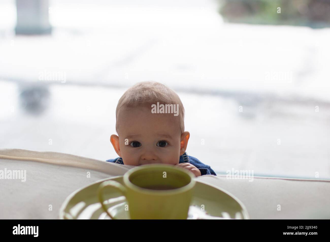 Niño curioso niño pequeño quiere hacer travesuras y está mirando hasta los padres cama a la taza caliente del café, copia abstracta espacio de fondo Foto de stock