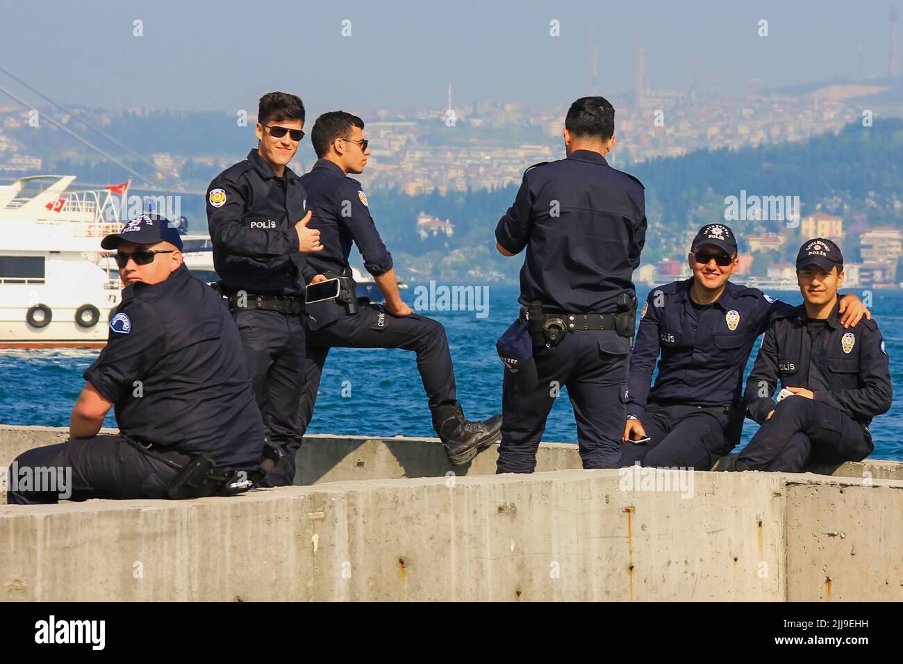 Grupo de jóvenes oficiales de policía turcos con elegante uniforme de policía descansan sobre el fondo borroso del Bósforo. Estambul, Turquía, mayo de 2015 Foto de stock