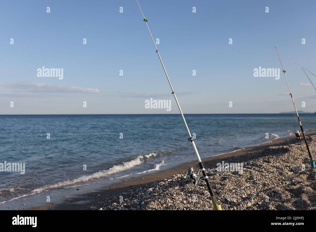Cañas de pescar en el mar mediterráneo en la playa paisaje costero y  concepto de pesca