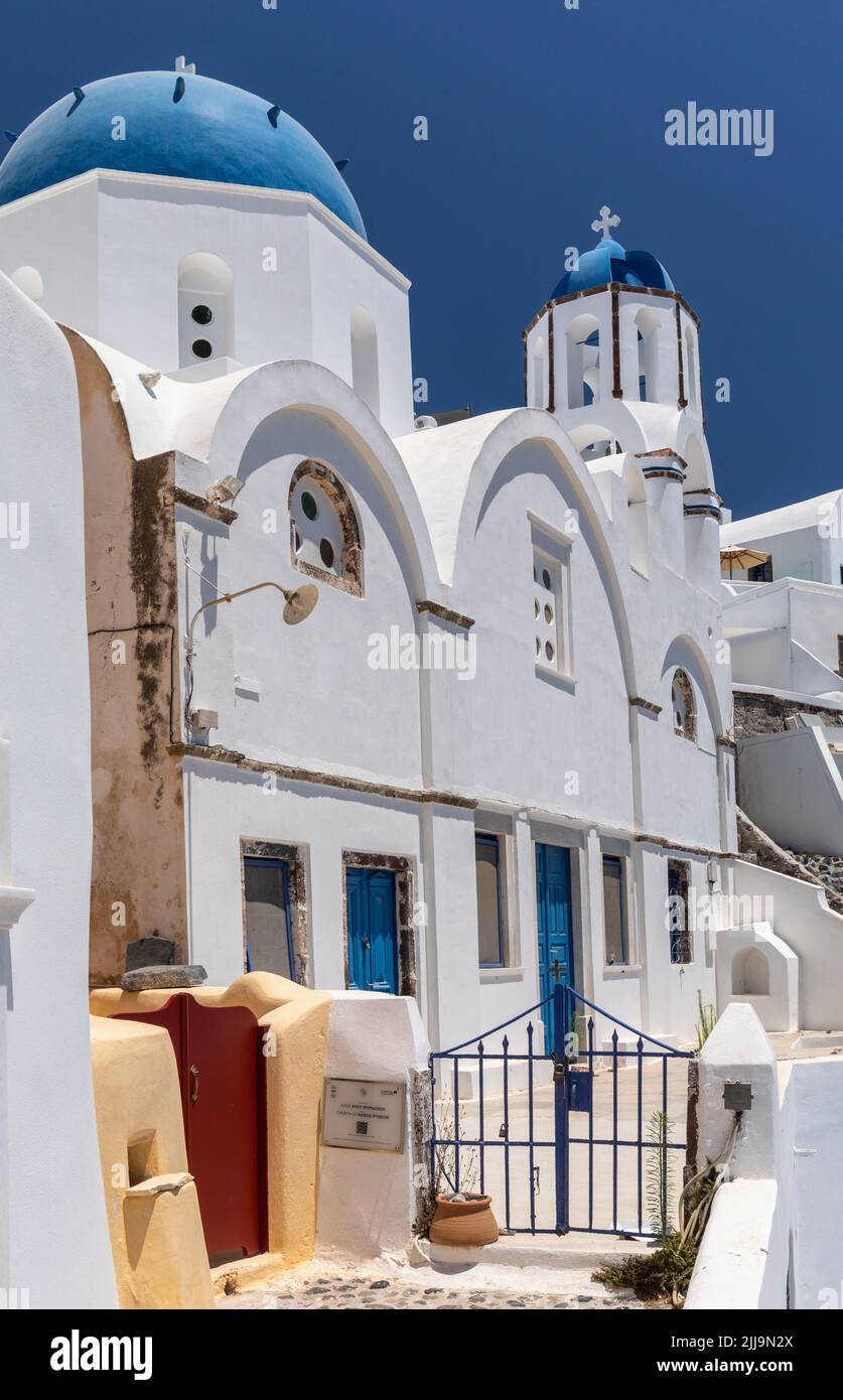 Iglesia de Hagios Spyridon con su famosa cúpula azul y campanario, Oia Santorini, Grecia Foto de stock