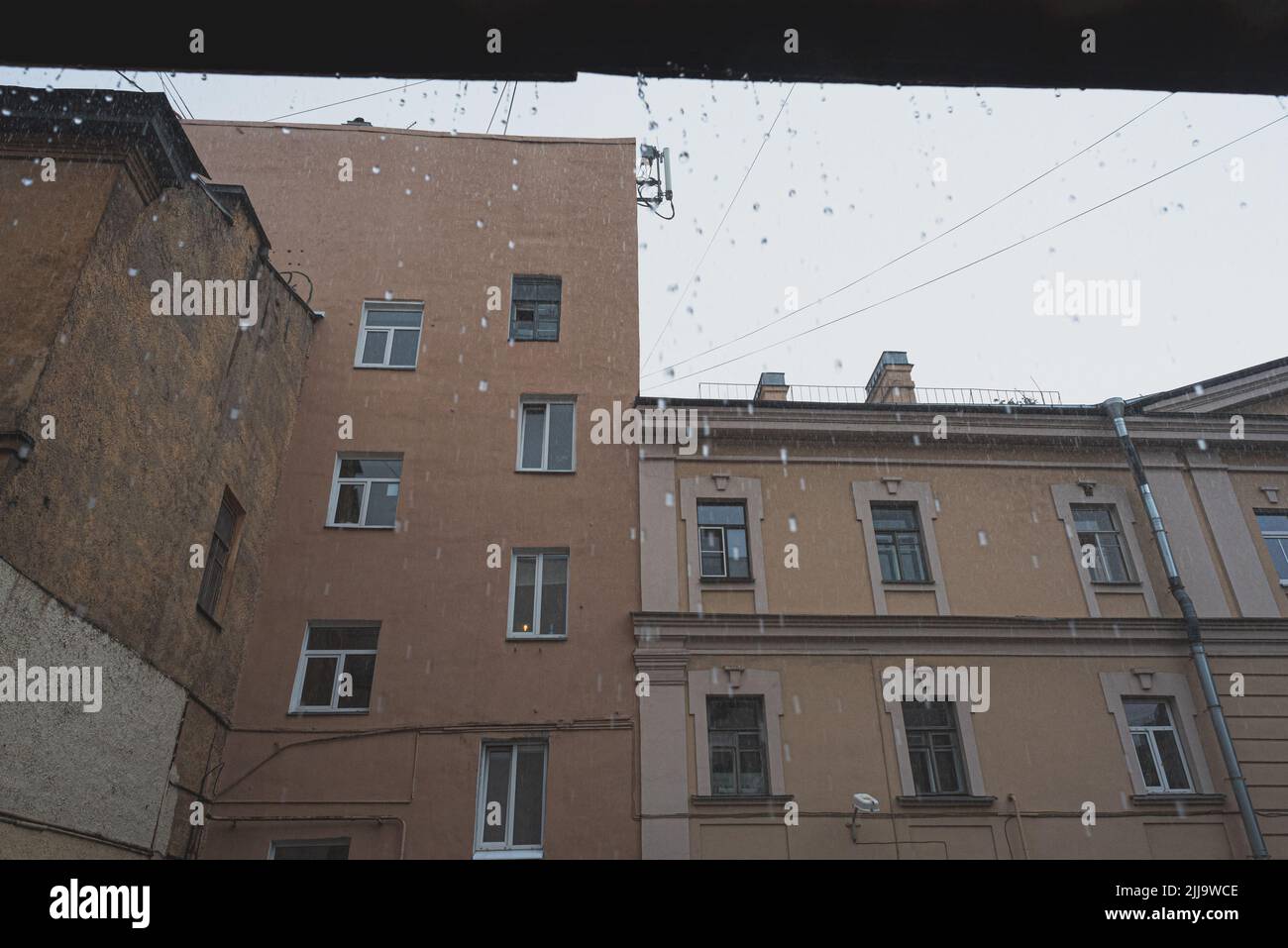 Lloviendo en la vieja ciudad europea. Las gotas que caen del cobertizo. Tiempo lluvioso. Foto de stock