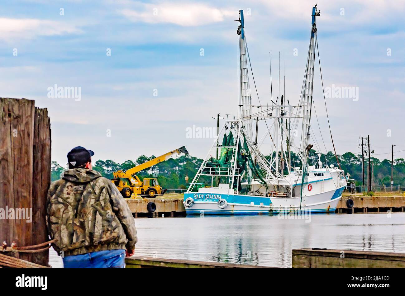 Un hombre mira fijamente a un barco camaronero, el 5 de enero de 2017, en Bayou La Batre, Alabama. Foto de stock