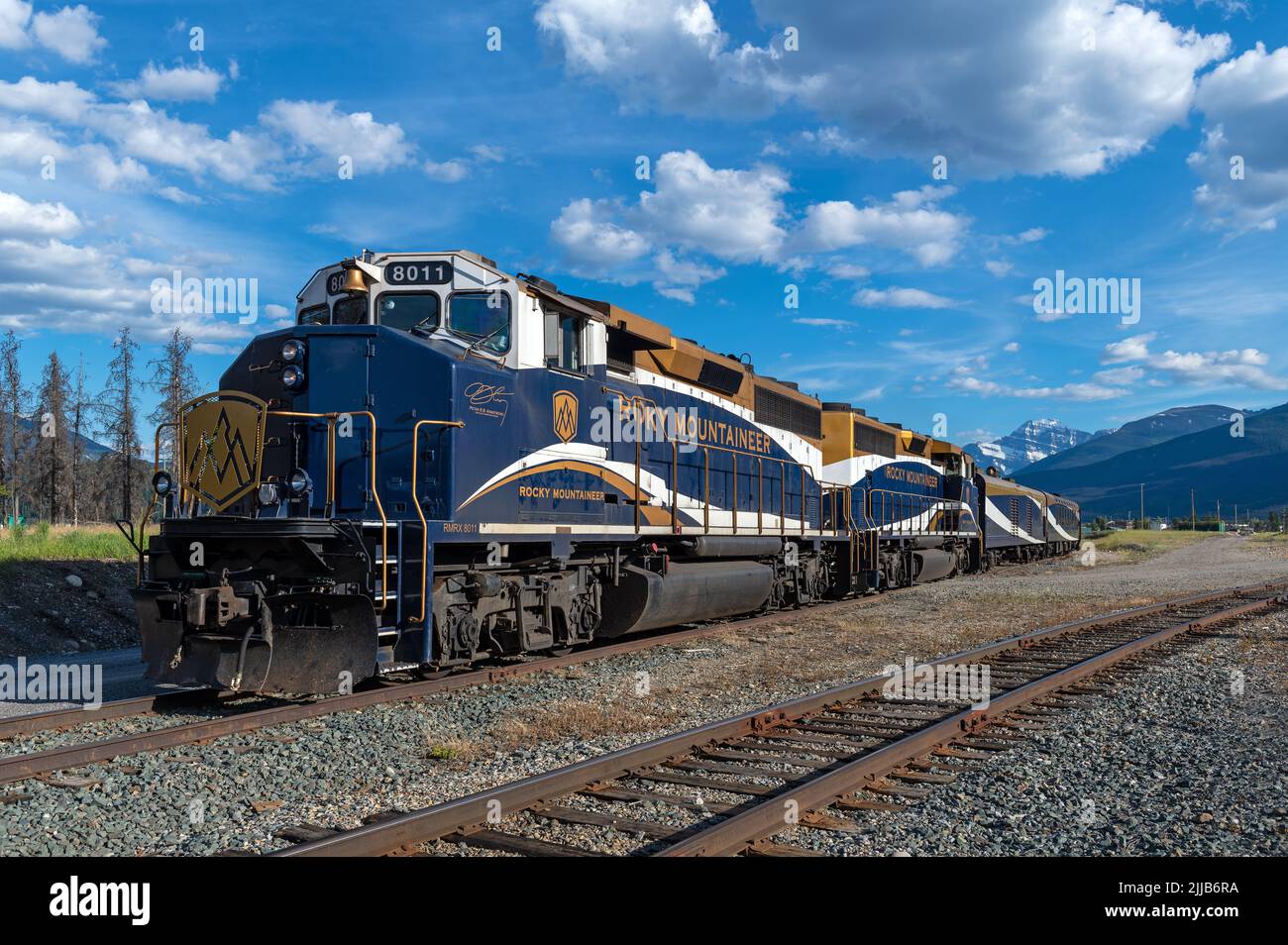 Locomotora de tren Rocky Mountaineer con vagones en las vías del ferrocarril de la estación de tren Jasper, Jasper, Alberta, Canadá. Foto de stock