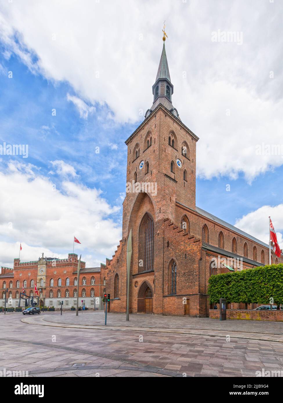 Odense Domkirke, la Catedral de San Canuto o la Catedral de Odense con el ayuntamiento en el fondo Foto de stock