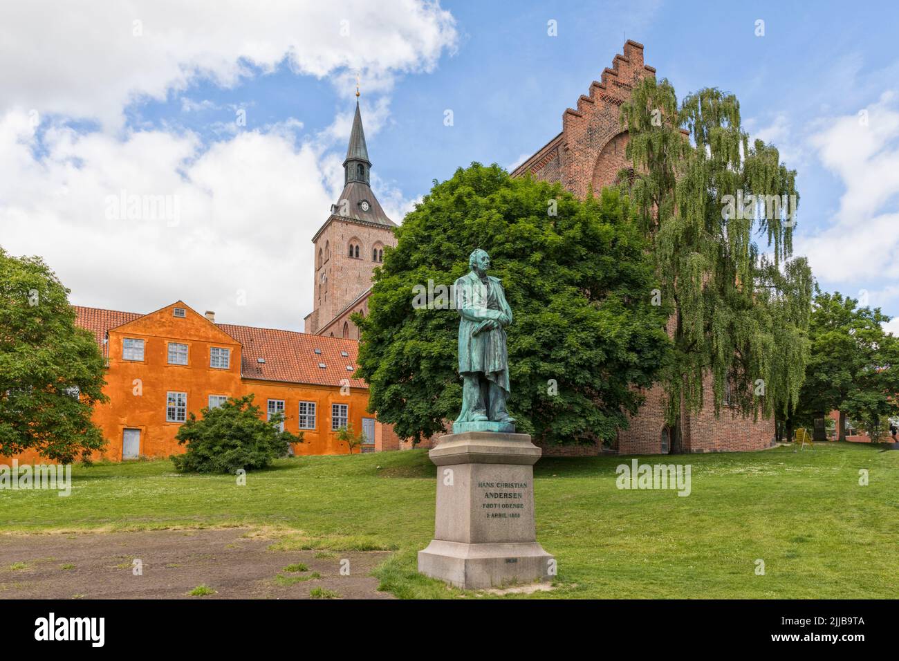 Monumento de 1888 para el autor danés Hans Christian Andersen. Catedral de Odense en el fondo. Foto de stock