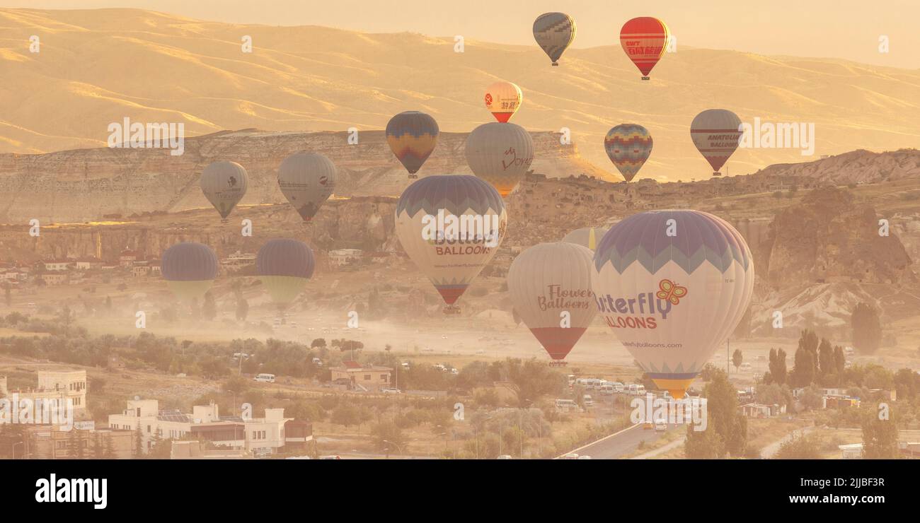 GOREME/TURQUÍA - 27 de junio de 2022: Un globo aerostático vuela bajo sobre la ciudad de goreme a primera hora de la mañana Foto de stock