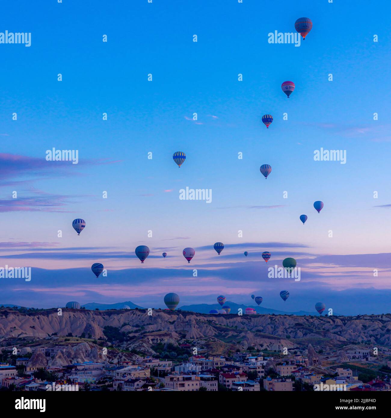GOREME/TURQUÍA - 29 de junio de 2022: Docenas de globos de aire caliente despegan al amanecer para transportar a los turistas. Foto de stock