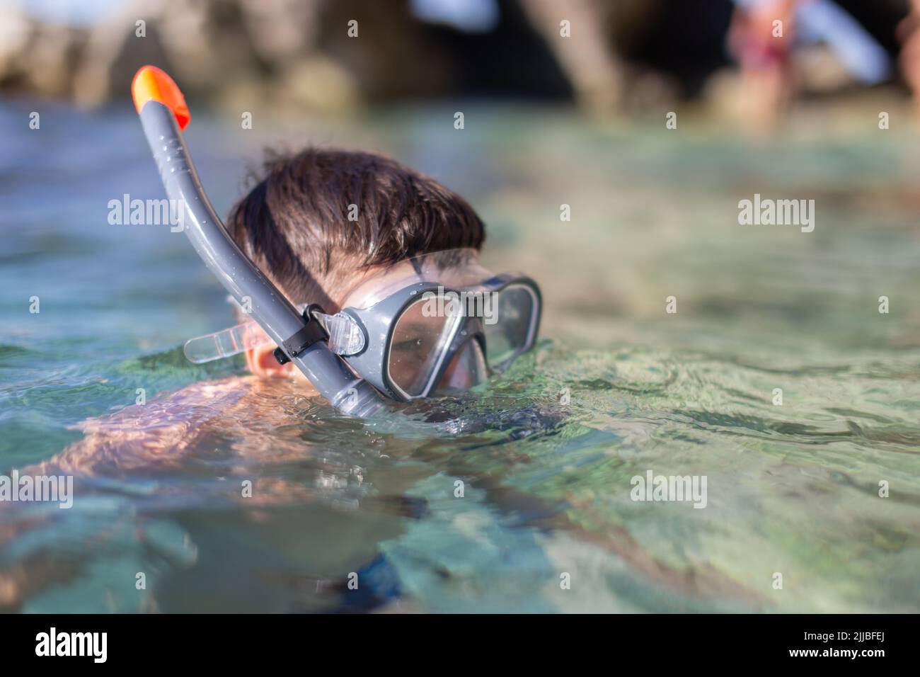 Joven caucásico haciendo actividad de buceo en la costa rocosa Foto de stock