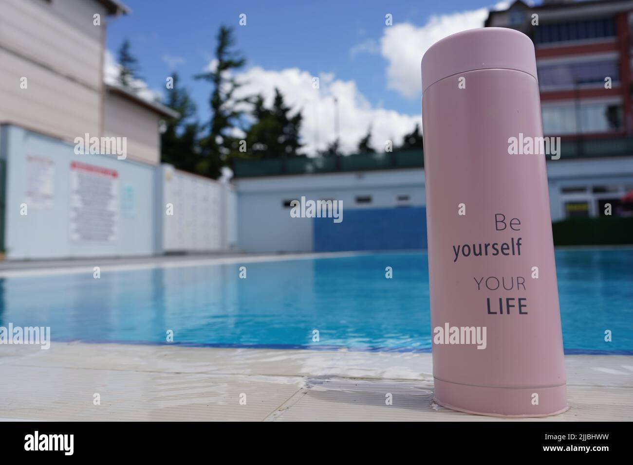Un termo para café, té y agua con 'Sea usted mismo, su vida' escrito en él  junto a la piscina Fotografía de stock - Alamy