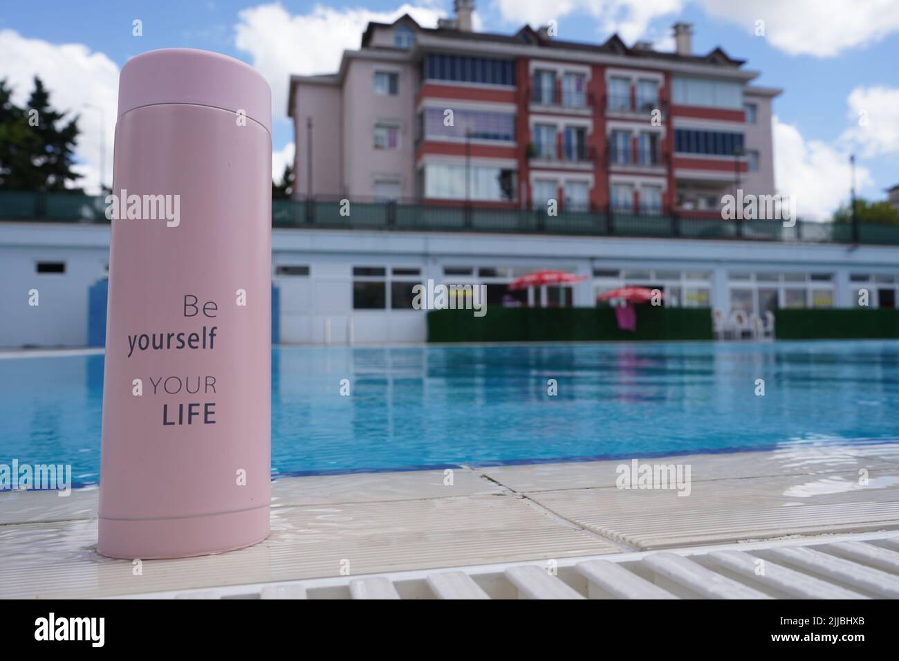 Un termo para café, té y agua con 'Sea usted mismo, su vida' escrito en él  junto a la piscina Fotografía de stock - Alamy