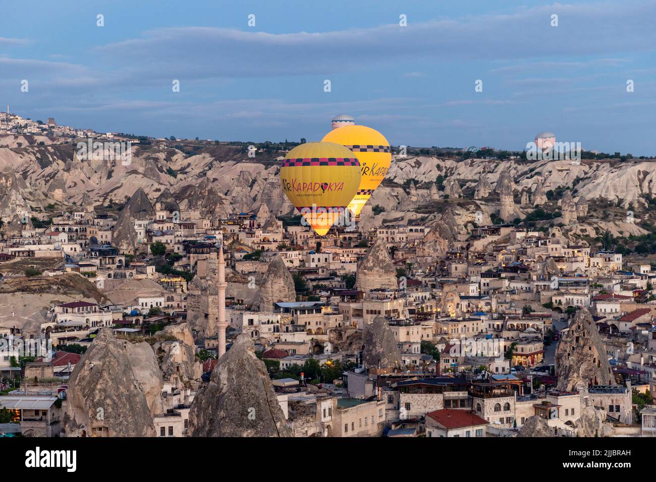 GOREME/TURQUÍA - 29 de junio de 2022: Globos de aire caliente vuelan a baja altura sobre la ciudad de goreme. Foto de stock