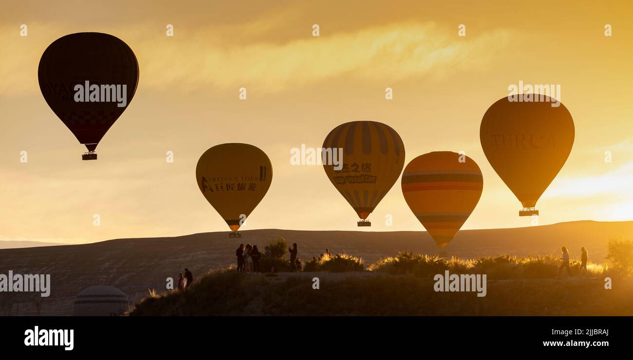 GOREME/TURQUÍA - 27 de junio de 2022: Globos de aire caliente vuelan al amanecer sobre goreme. Foto de stock