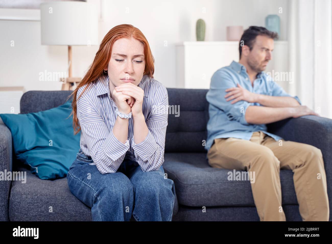 Una pareja molesta y triste discutiendo unos con otros en el sofá Foto de stock