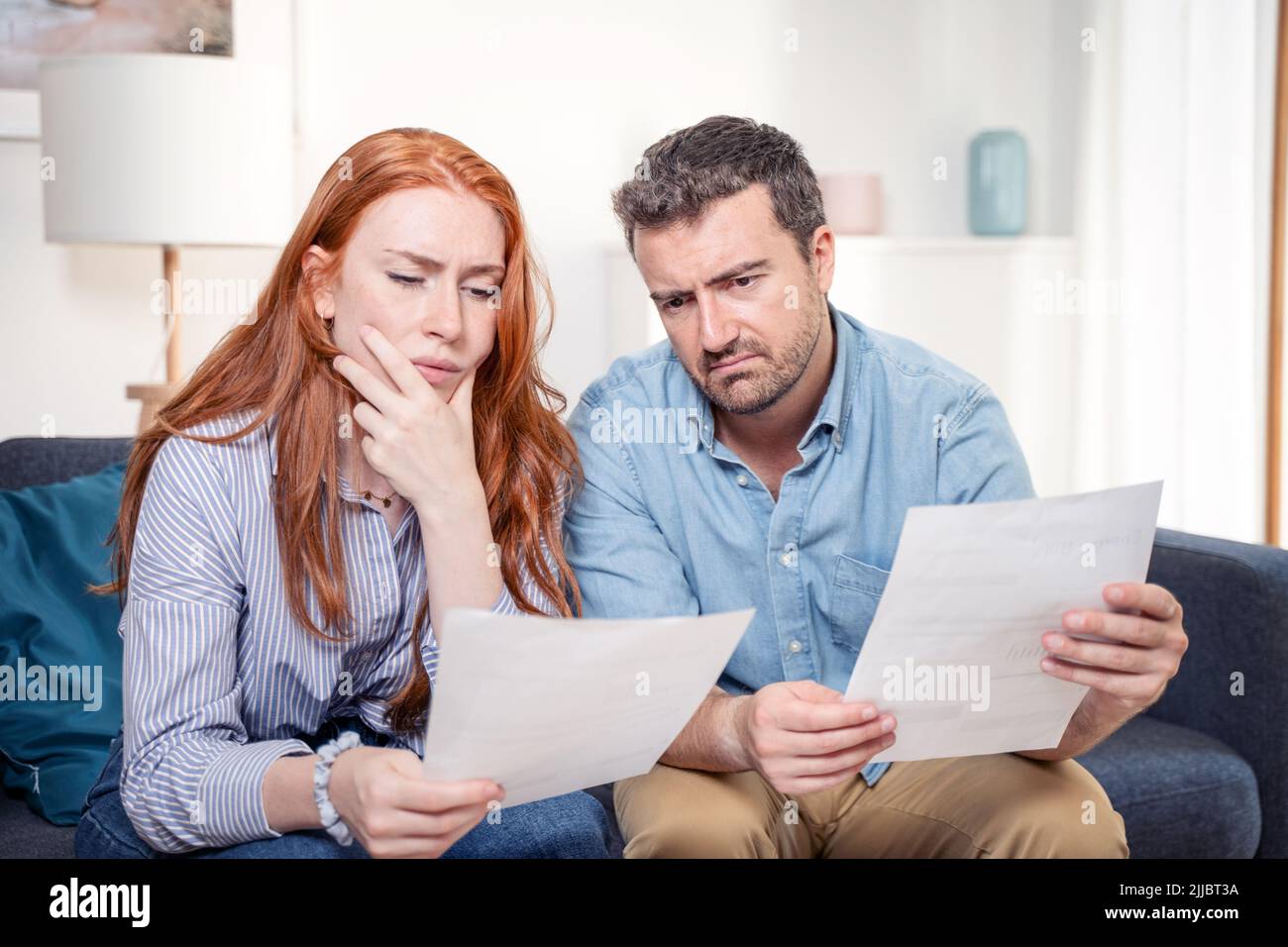 Joven pareja caucásica que tiene problemas de deuda después de los gastos del hogar Foto de stock