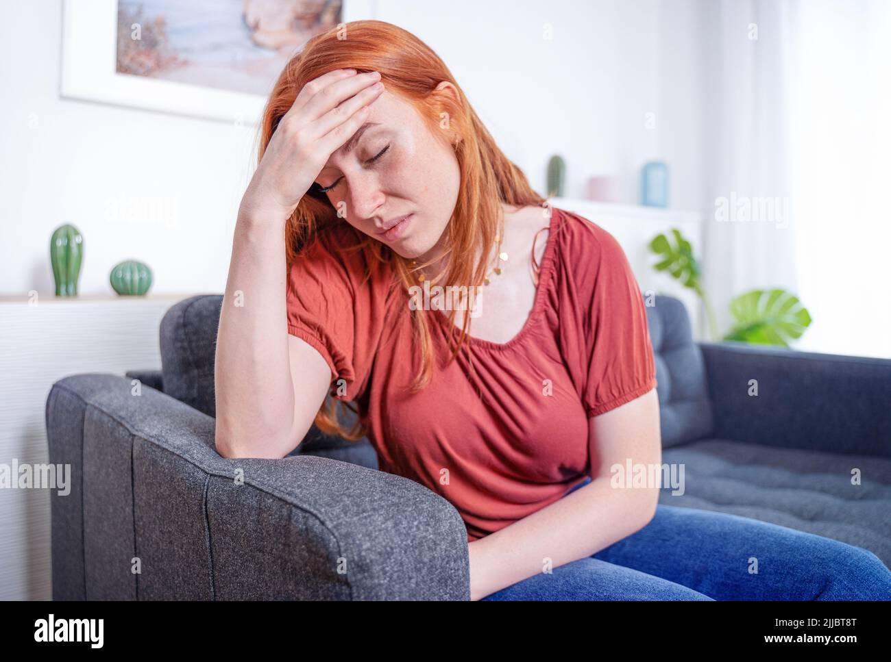 Mujer joven en el hogar que sufre dolor de cabeza crónico severo Foto de stock