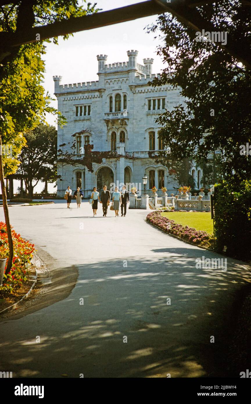 Personas caminando en coche desde el castillo Miramare, Trieste, Italia 1959 Foto de stock