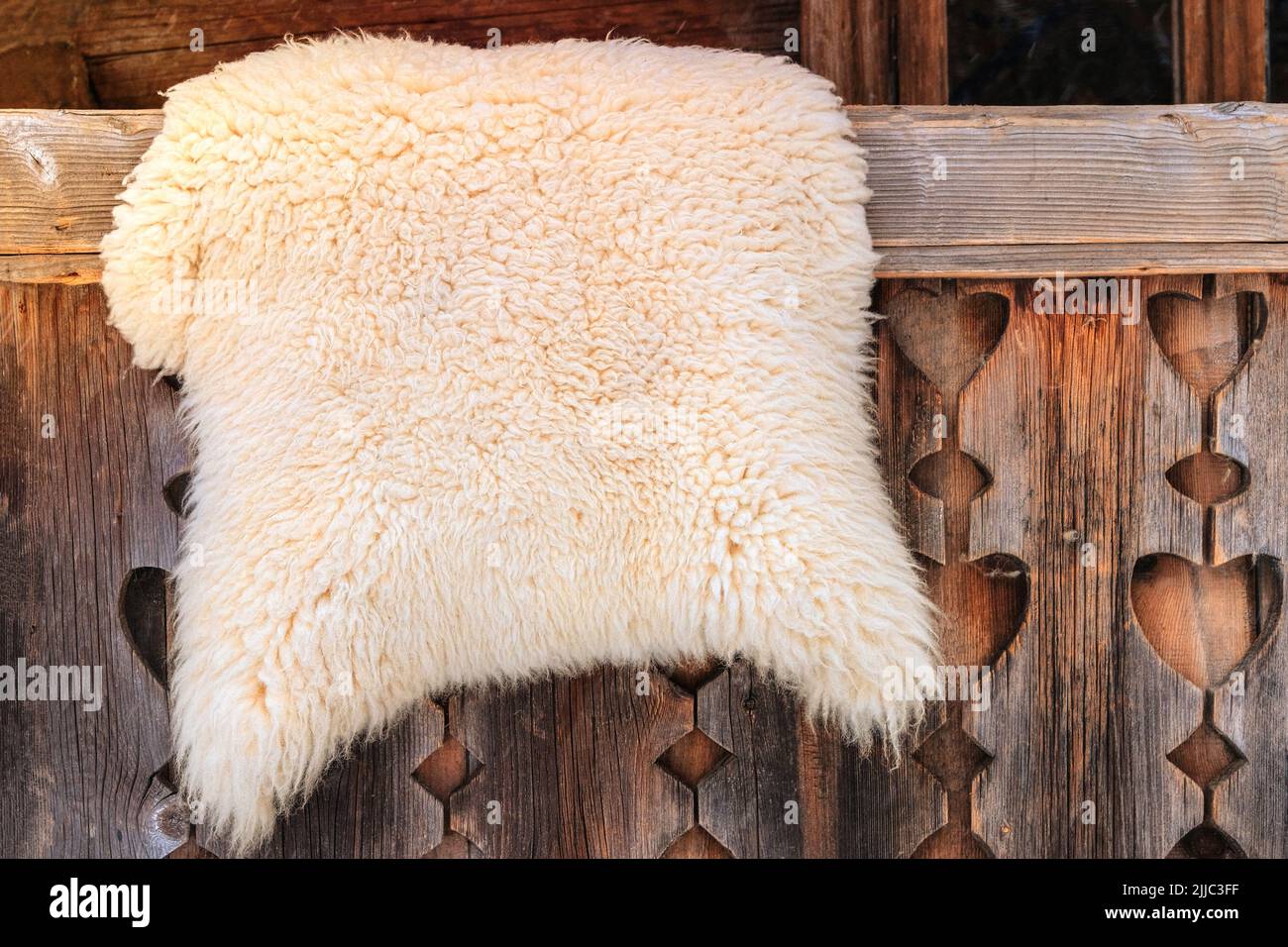 Piel de oveja sobre una valla de madera en el campo rural. Concepto de viaje, turismo y medio ambiente. Foto de stock