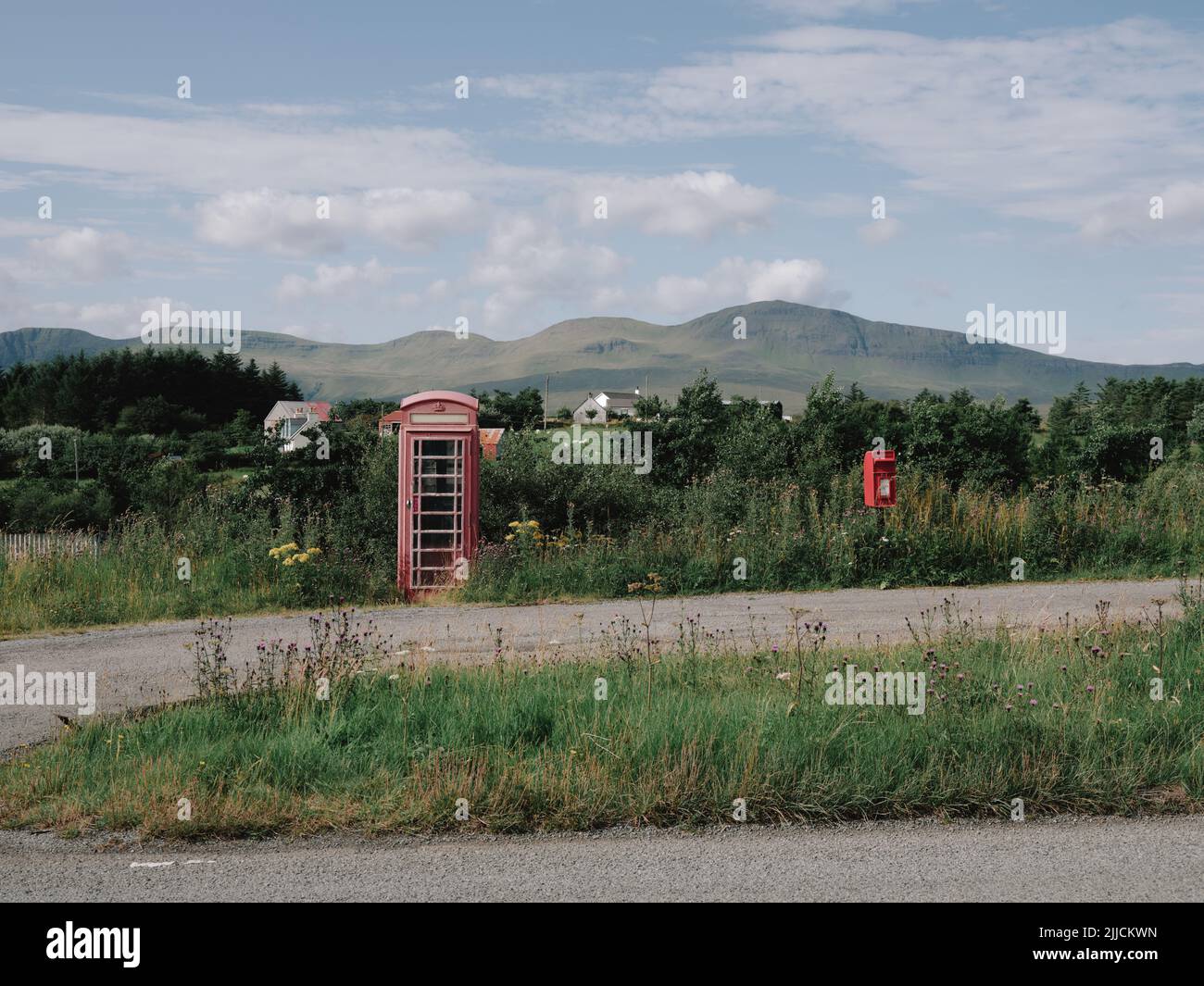 Una caja de teléfono roja y una caja de correo Royal Mail en el remoto y aislado paisaje de la península de Trotternish, Isla de Skye, West Highlands, Escocia, Reino Unido Foto de stock