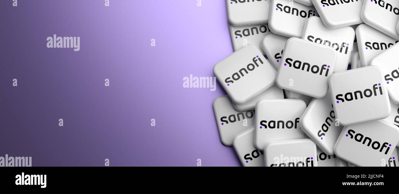 Logos de la compañía farmacéutica y sanitaria francesa Sanofi en un montón sobre una mesa. Espacio de copia. Formato de banner web. Foto de stock