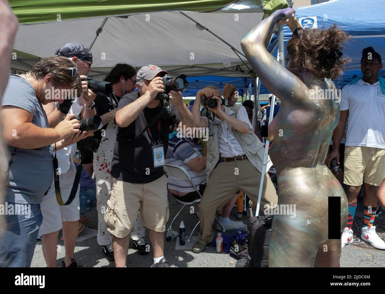 Los fotógrafos sacan la foto de una mujer que fue pintada con un acabado metálico. En el Día de Pintura Corporal de Nueva York en Union Square Park en Manhattan, Nueva York Foto de stock