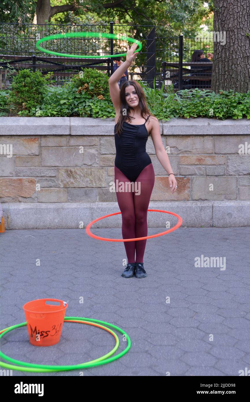 Miss 360, una artista callejera que trabaja con hula Hoops, actuando en Union Square Park en la ciudad de Nueva York Foto de stock