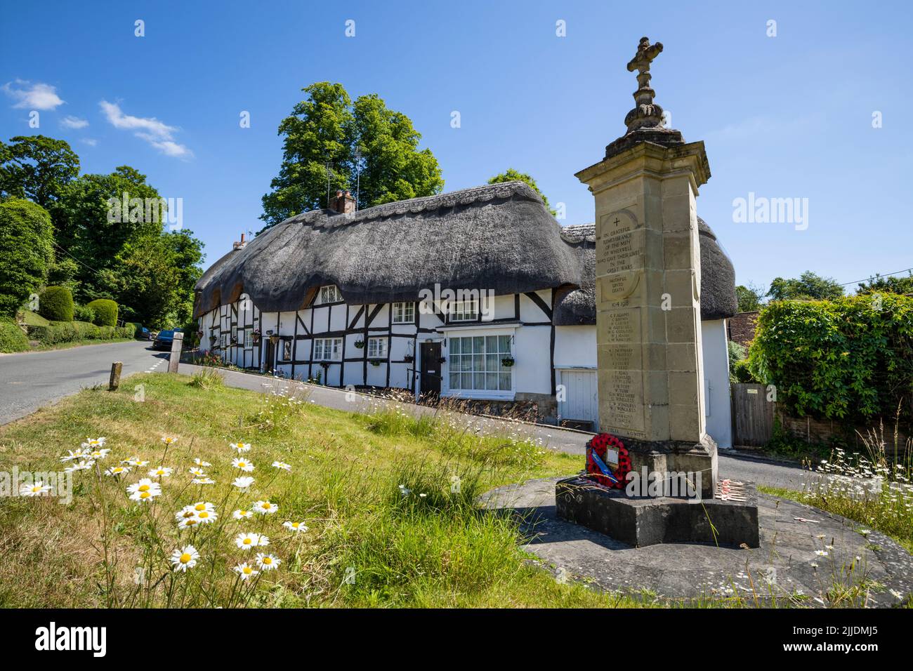 Casas con techo de paja y el Monumento a la Guerra en la plaza del pueblo, Wherwell, Test Valley, Hampshire, Inglaterra, Reino Unido, Europa Foto de stock