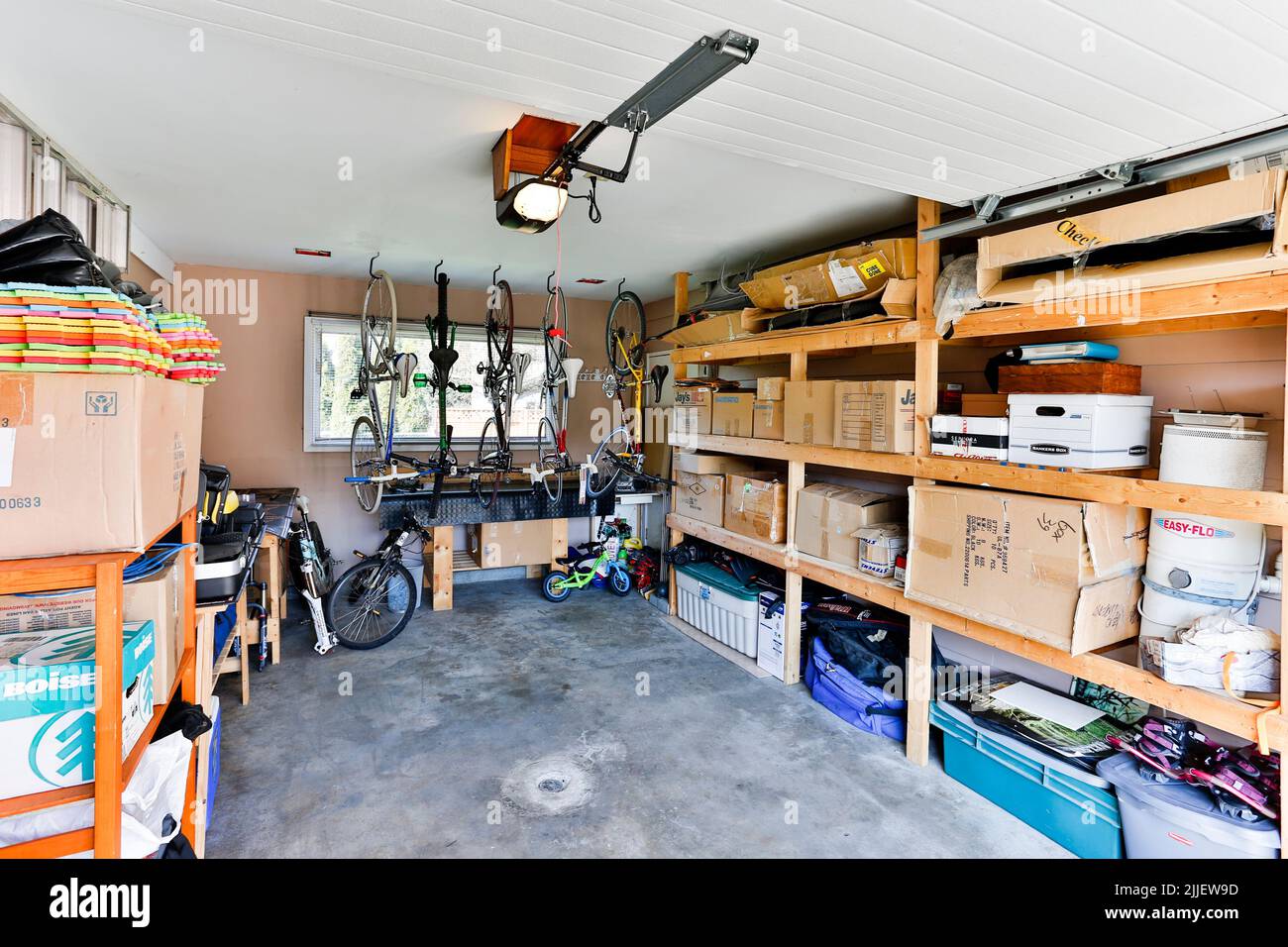 Squamish, British Columbia, Canadá - 2 de abril de 2016: Un almacenamiento de garaje de casa interior organizado lleno de cosas personales y basura apilados en estanterías. Foto de stock