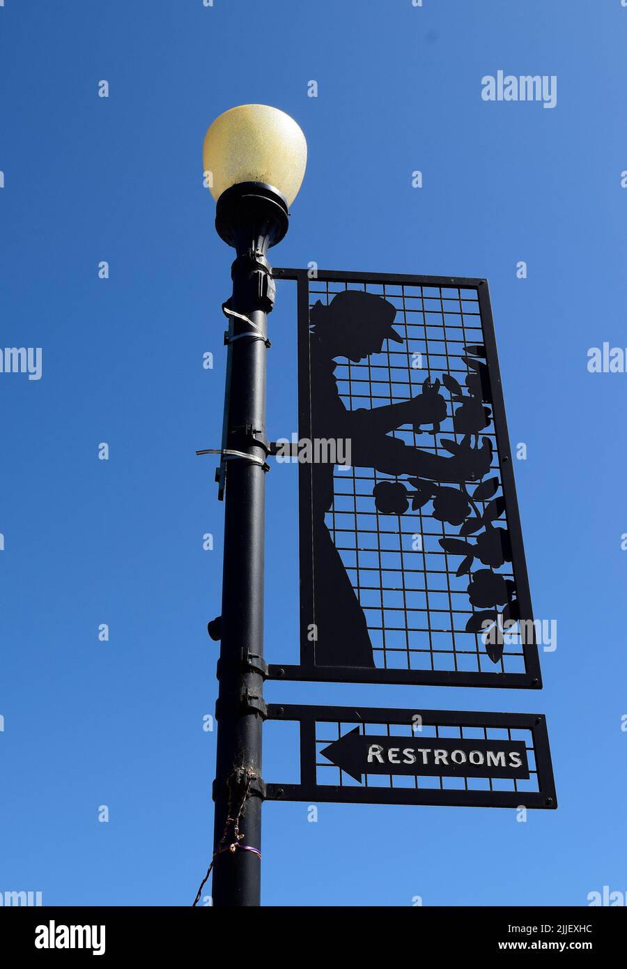 Letrero de la flecha de la dirección de los baños en el poste de la lámpara en el districto de Niles, de Fremont, de California, americano, EE. UU., EE. UU. Foto de stock