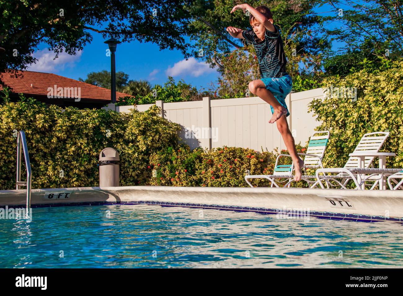 Disfrute del increíble clima de Florida y de la piscina al aire libre.  Niños saltando a la piscina. Piscina al aire libre en el sur de Florida  Fotografía de stock - Alamy