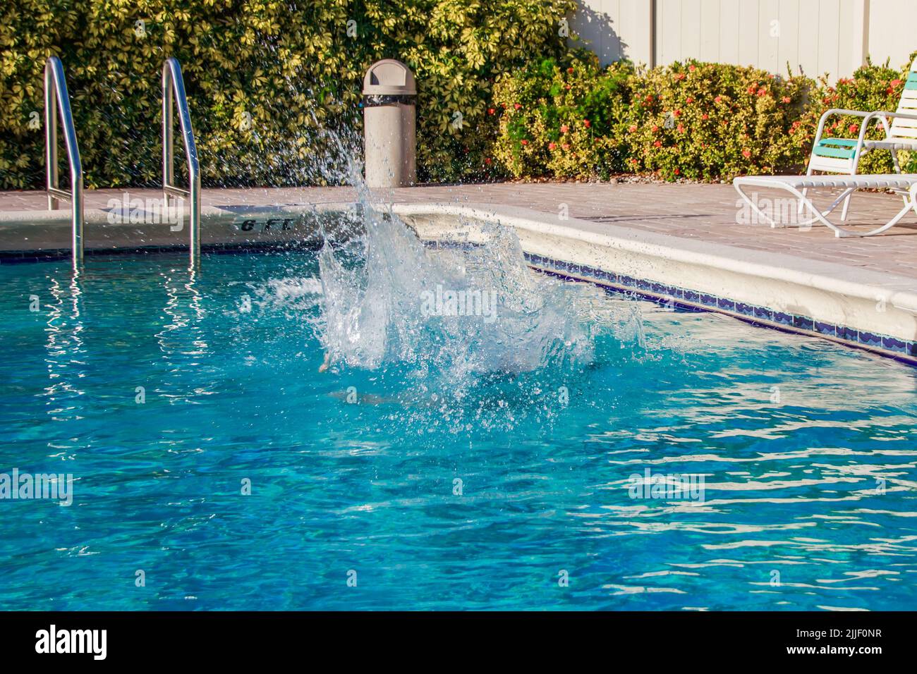 Disfrute del increíble clima de Florida y de la piscina al aire libre. Niños saltando a la piscina. Piscina al aire libre en el sur de Florida. Foto de stock
