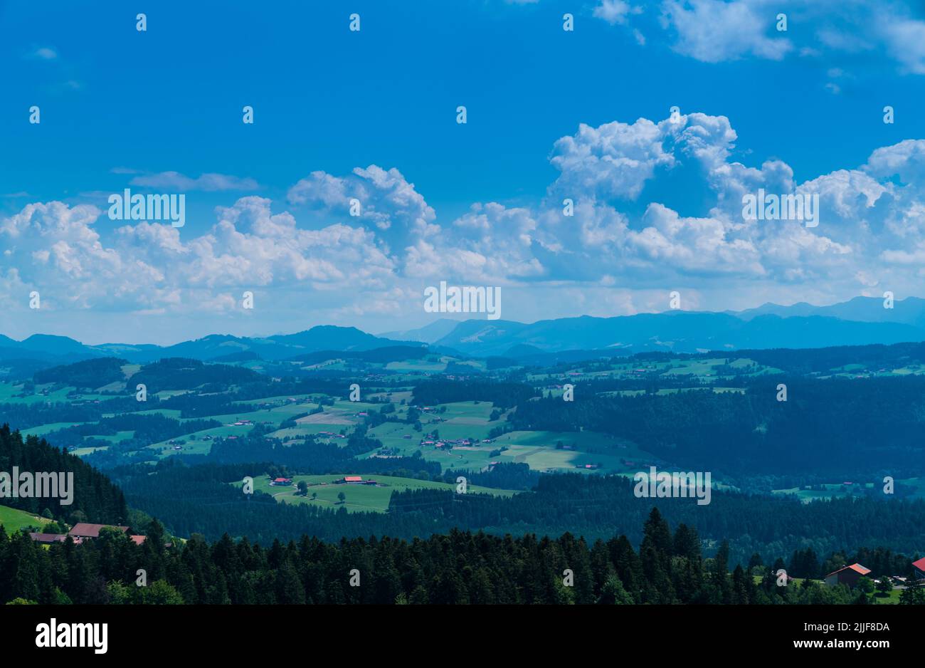 Alemania, vista panorámica sobre el bosque y prados en la cima de un pico de montaña con las nubes y el sol en allgaeu paisaje natural perfecto para el senderismo Foto de stock