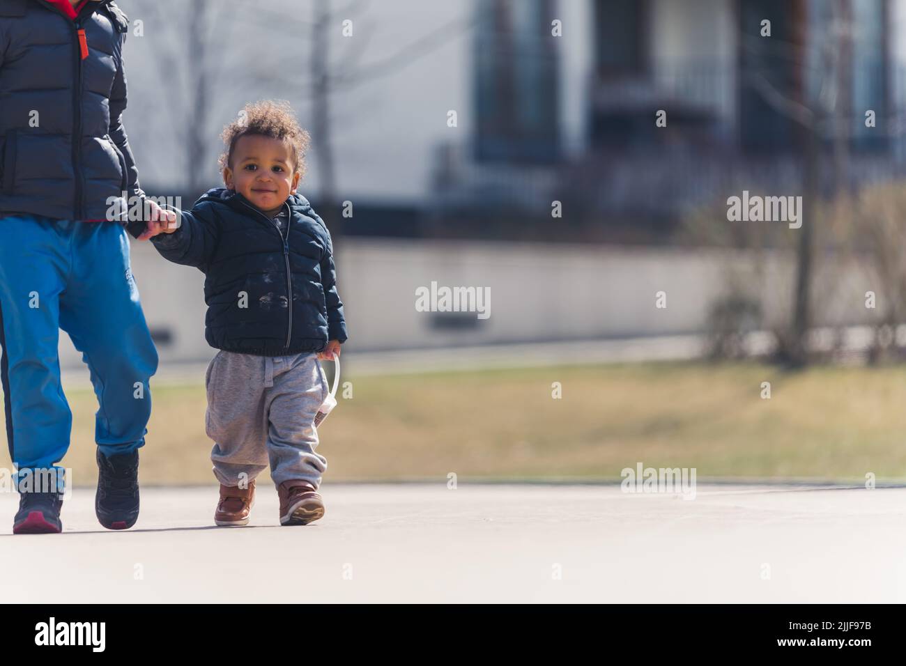 Pequeño niño afroamericano caminando fuera con su amigo. Fotografía de alta calidad Foto de stock