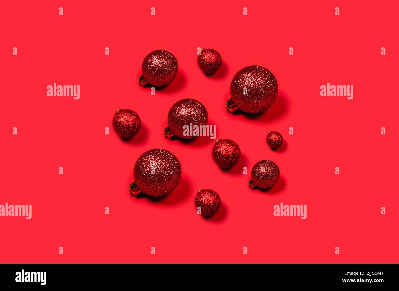 Bolas de Navidad rojas dispuestas en forma de círculo sobre fondo brillante. Foto de stock