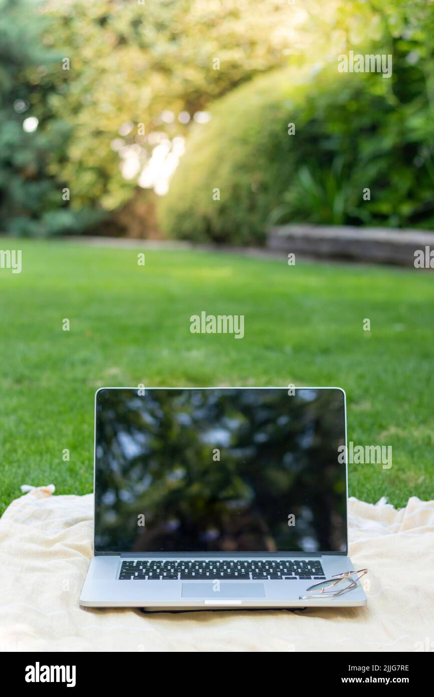 Vista vertical de portátil aislado con fondo borroso Reflexiones en la pantalla  para trabajos en línea y nómadas digitales en el mundo Fotografía de stock  - Alamy