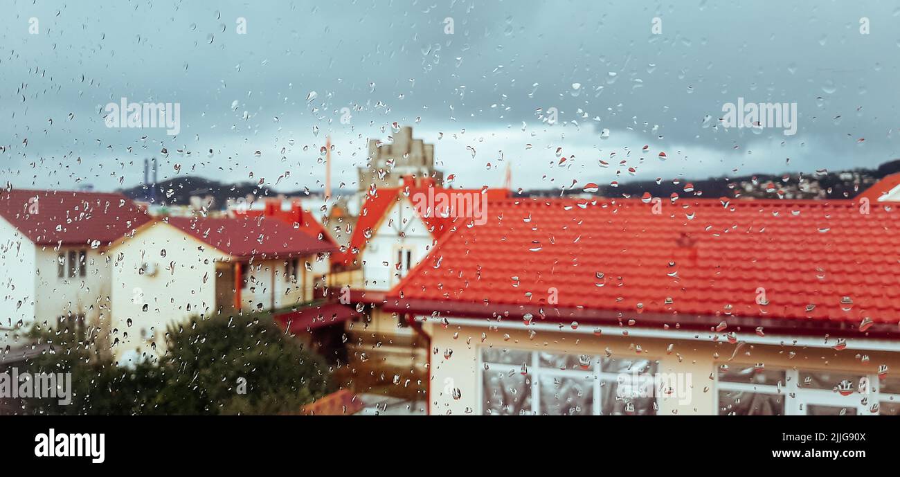 Gotas de lluvia en la ventana. Fuera de la ventana del paisaje urbano. Foto de stock