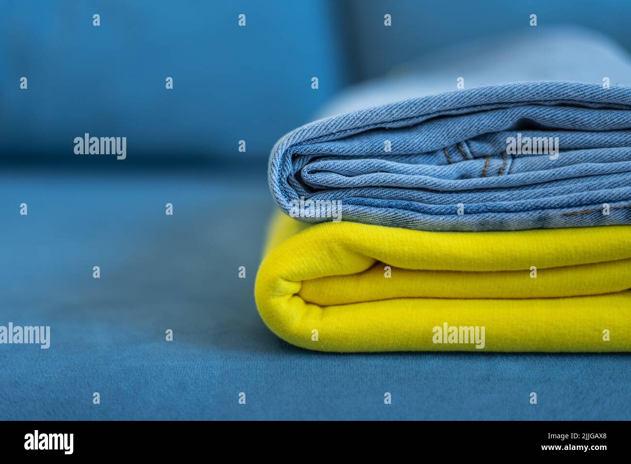 Las ropas de colores brillantes están cuidadosamente apiladas. Los colores amarillo y azul de la bandera ucraniana. Foto de stock