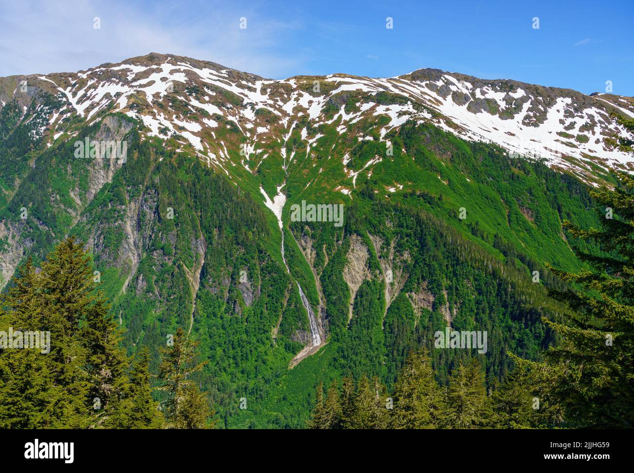 Vista desde la parte superior del tranvía hacia el Monte Juneau y su cascada sobre la ciudad de Alaska Foto de stock