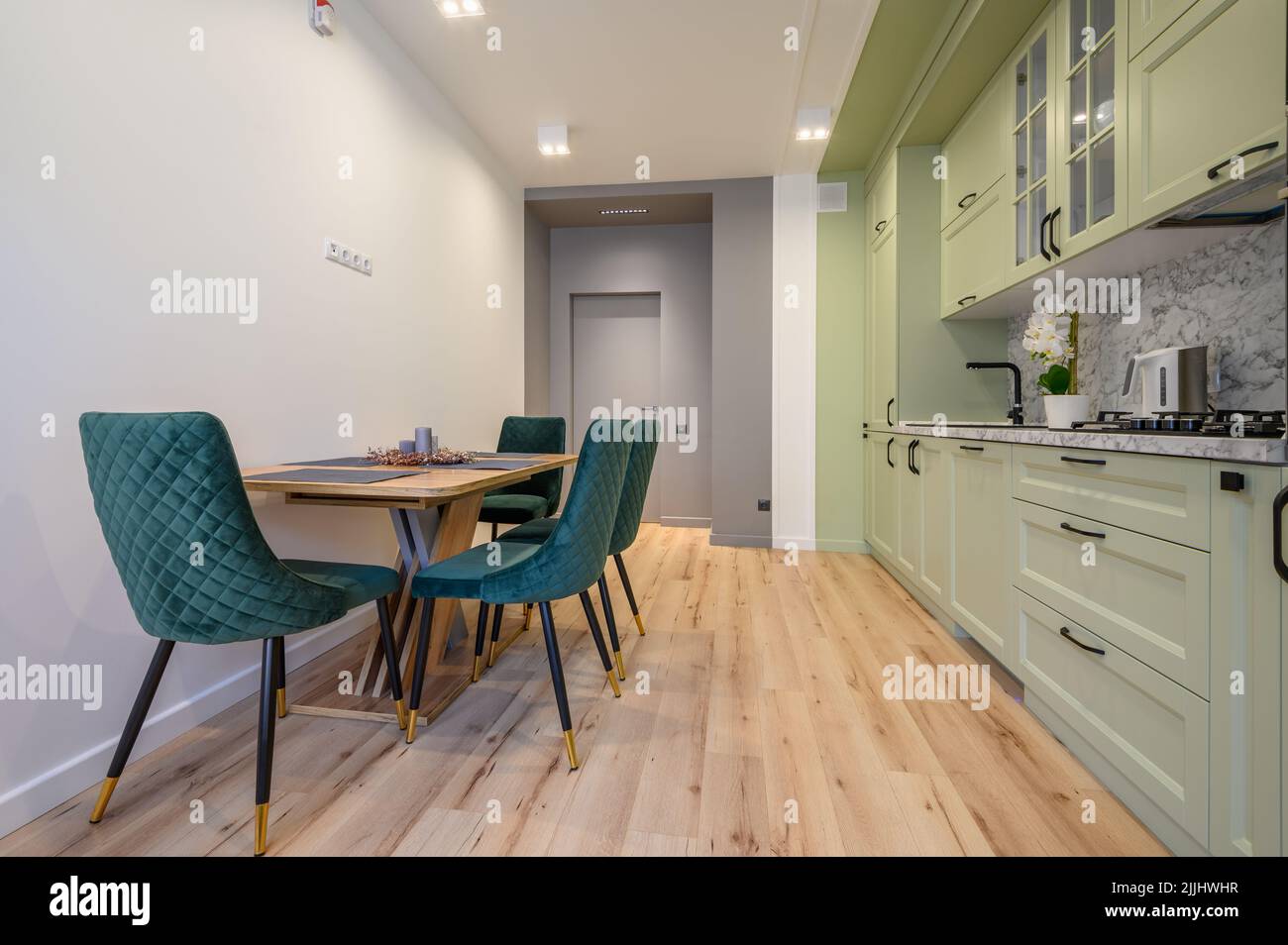Moderna cocina verde claro y lujosa con mesa de comedor Foto de stock