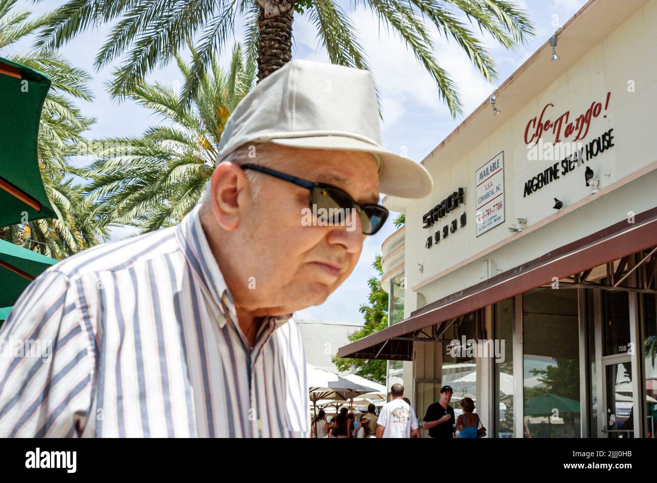 Miami Beach Florida, centro comercial peatonal Lincoln Road, anciano pensionista ner jubilado anciano que llevaba gafas de sol sobre postura doblada Foto de stock
