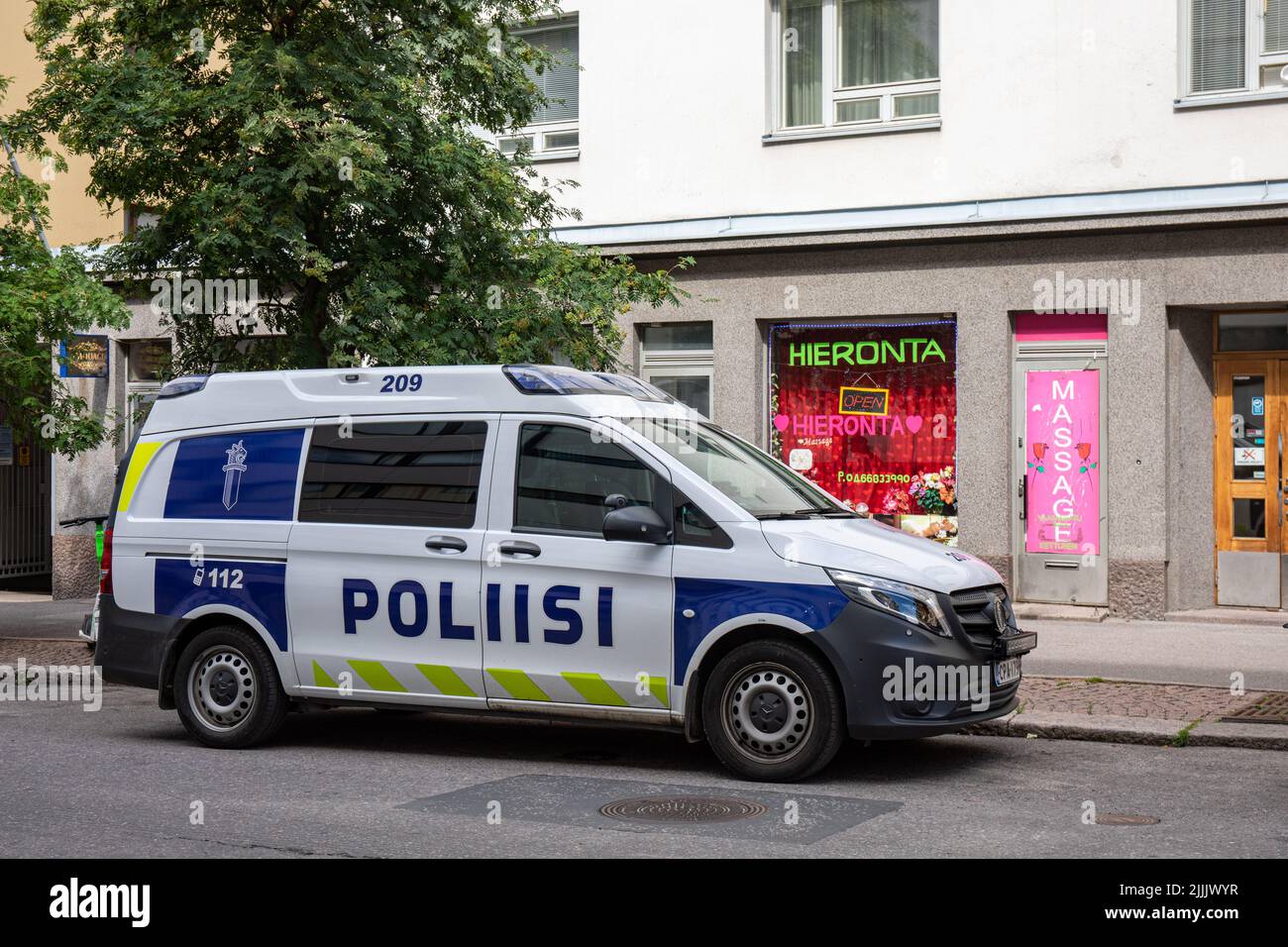 Furgoneta de policía frente a la sala de masajes en Vaasankatu, Helsinki, Finlandia Foto de stock