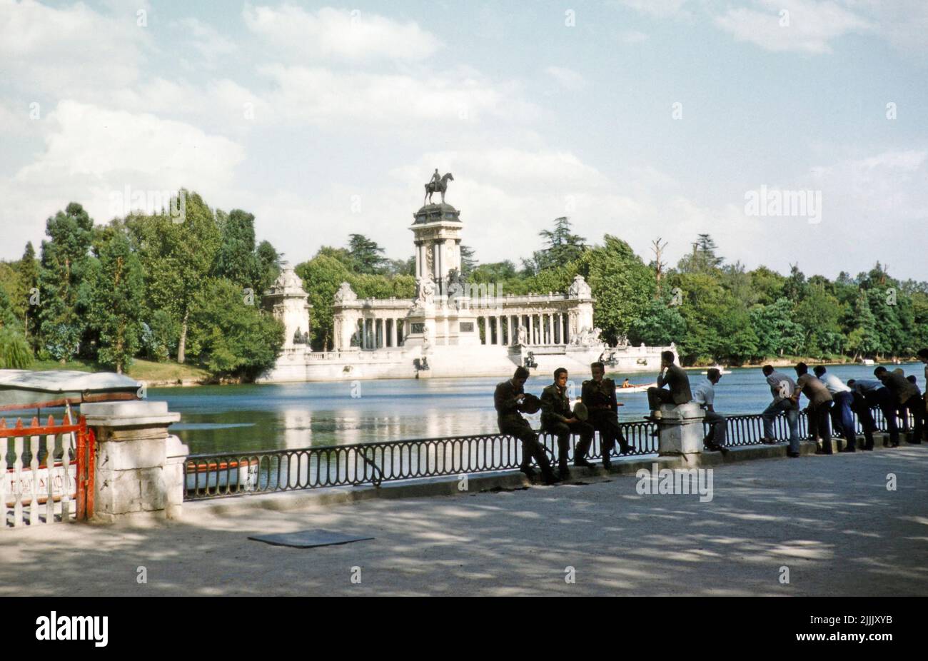 Hombres junto al lago en el Parque del Retiro, estatua ecuestre monumento al rey Alfonso XII, Madrid, España 1959 Foto de stock