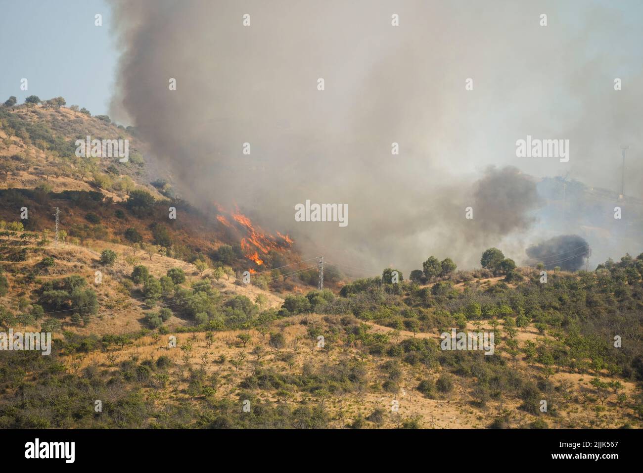 Un incendio forestal en el campo de Mijas es combatido con helicópteros, Mijas, Andalucía, España. Foto de stock