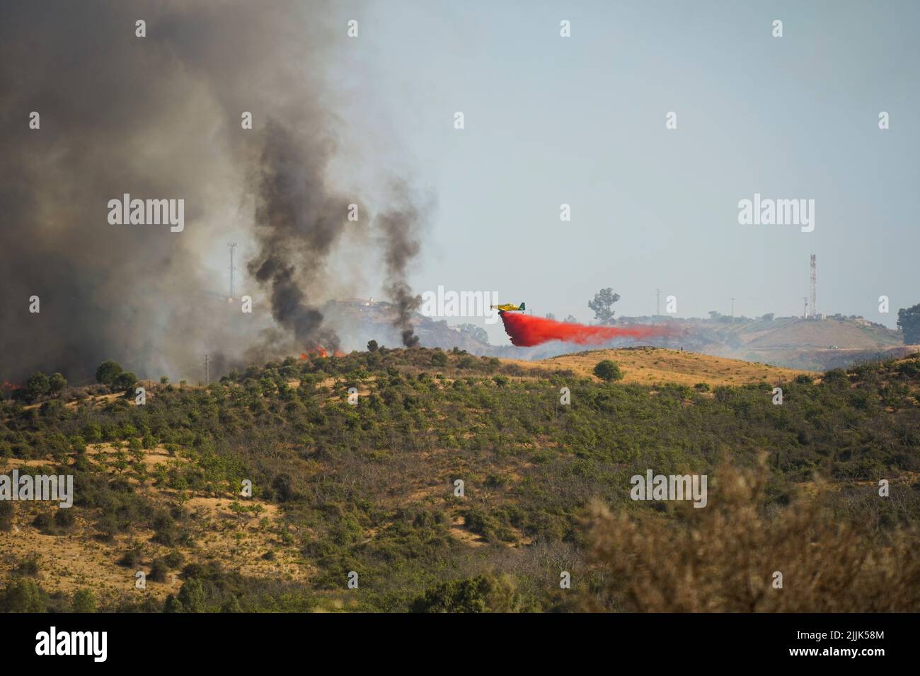 Avión cayendo retardante de llama roja sobre incendios forestales en Mijas, Andalucía, España. Foto de stock