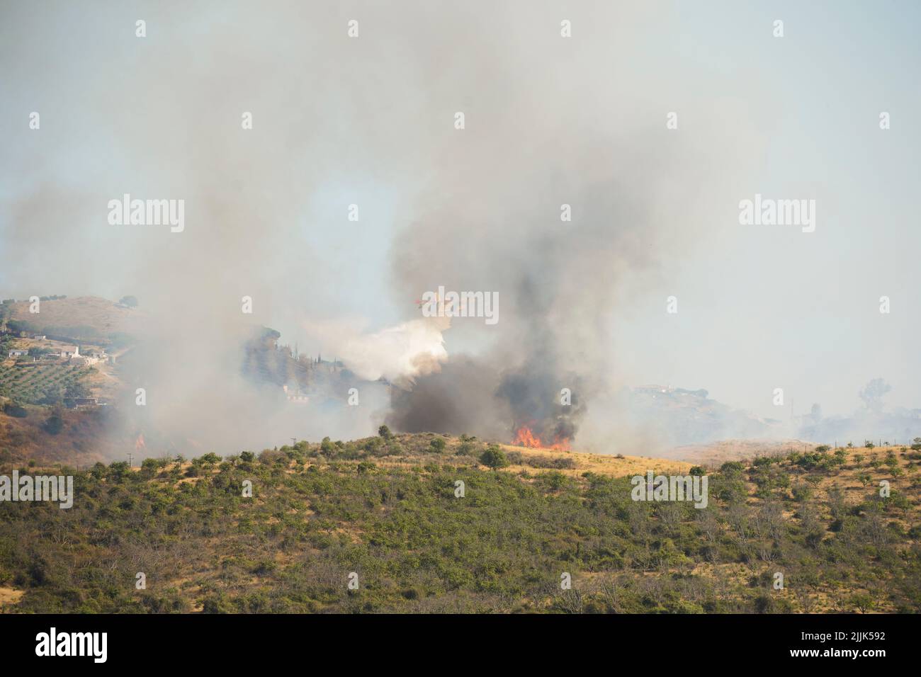 Avión anfibio que cae agua sobre los incendios forestales en el campo de Mijas, Mijas, Andalucía, España. Foto de stock