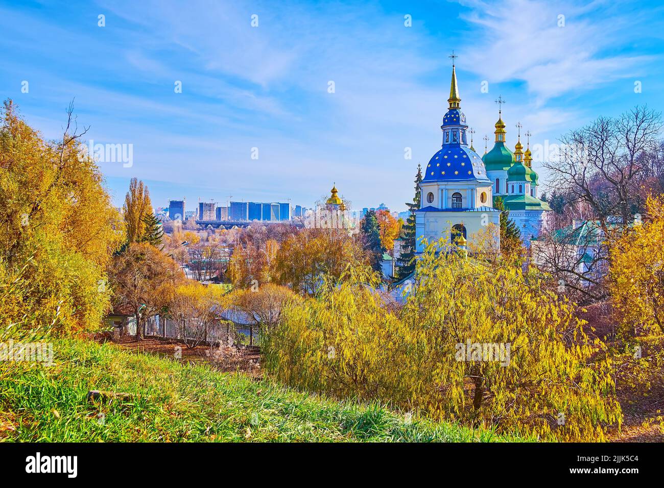 La colina en el jardín botánico de Kiev observa las cúpulas azules y verdes brillantes del monasterio de Vydubychi, visto detrás de los sauces amarillos del otoño, Kiev, Ukrain Foto de stock